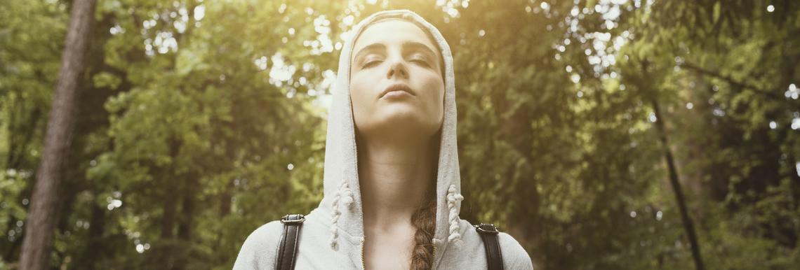 Relaxed young woman walking in nature and feeling relaxed, sunlight shining through trees, relax and mindfulness concept, Stock image mindful