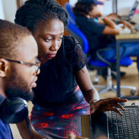 a man and a woman solving a problem on a laptop