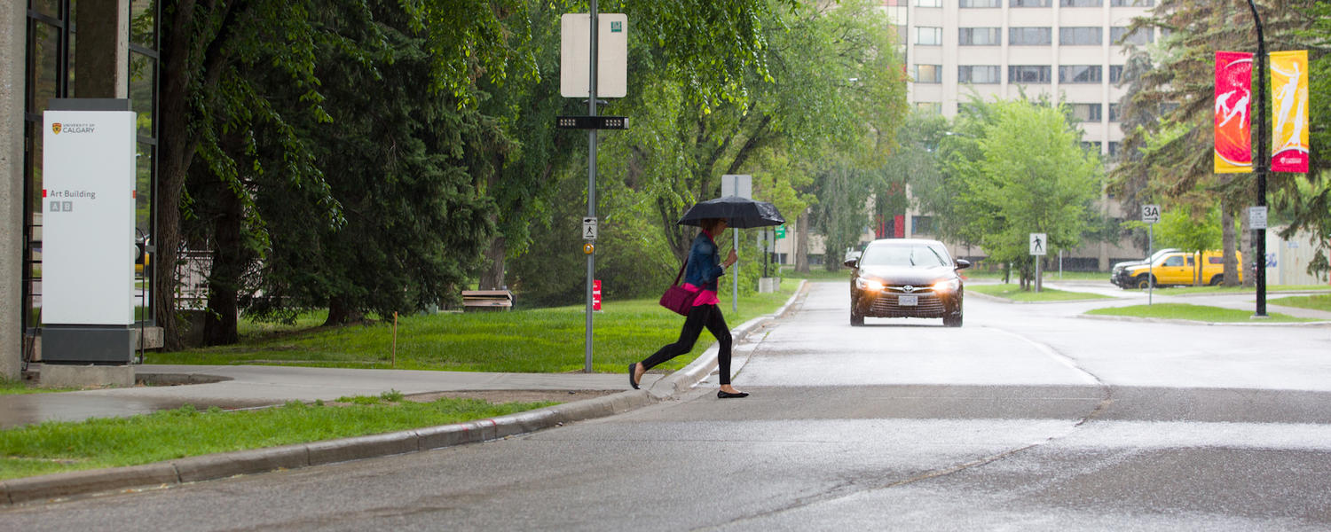 student running across campus in the rain