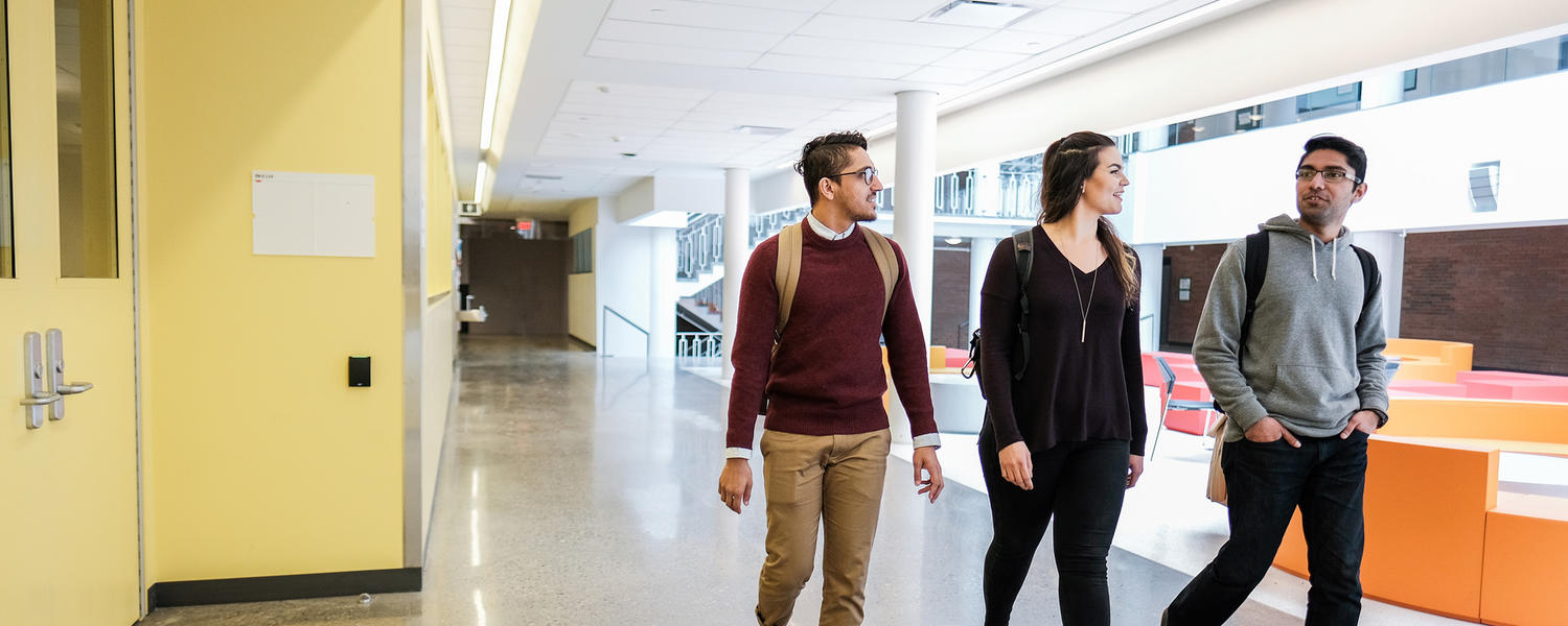 three students walking in a hallway