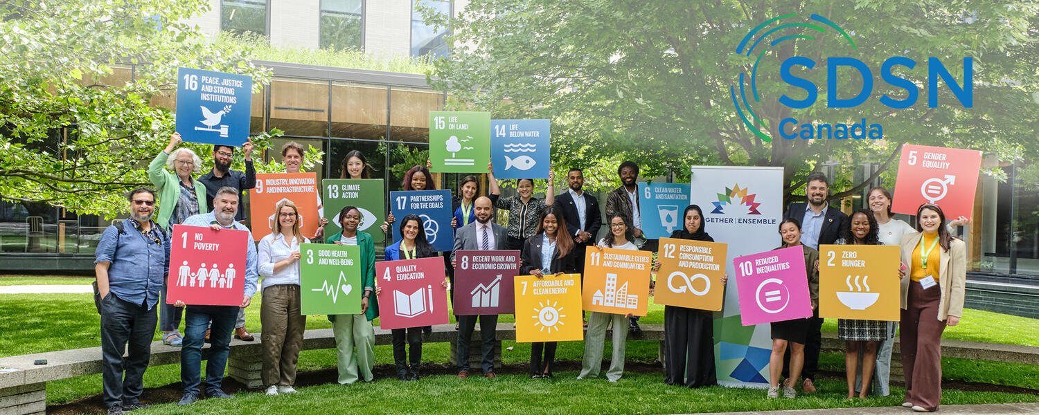 People holding SDG banners in a field 