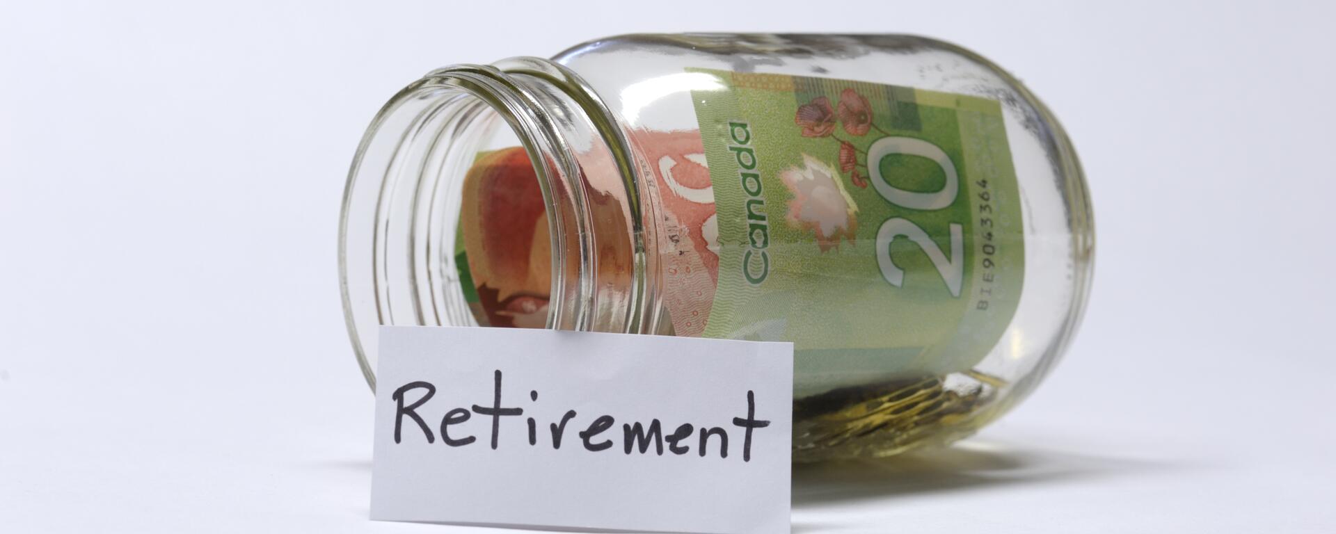 A photograph of a jar with money in it, with a sheet of paper that says "retirement" on it.
