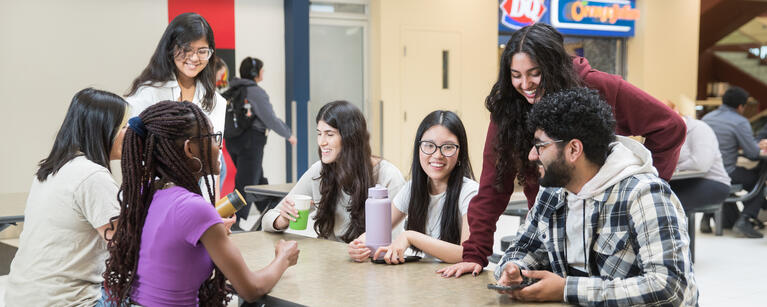 Students gathered at a table, discussing.