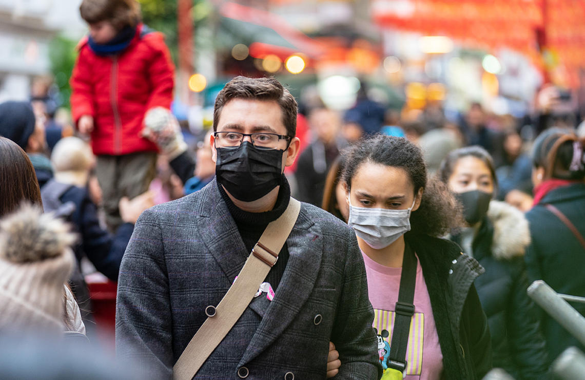 A crowd of people wearing masks in public