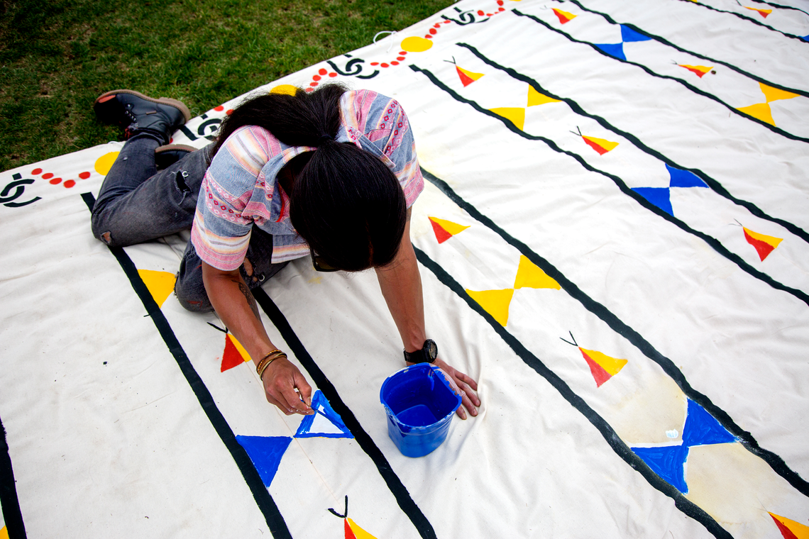 A girl drawing symbols with blue paint 