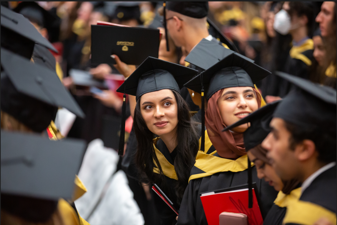 Photo of a group of people in graduation gowns and caps