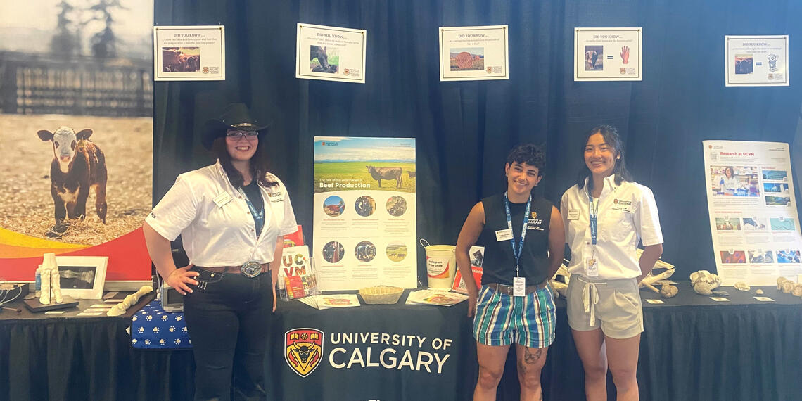 A group of people stand in front of a vet med booth at the calgary stampede