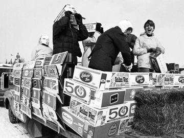 UCalgary students use empty beer cases to build a float on the back of a flat-bed truck at Stampede Park during the 1969 Bermuda Shorts Day