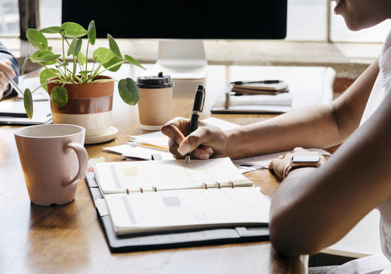 Person writing notes at a desk