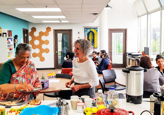 Hindu and Bahai representatives laughing over food