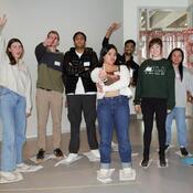 A group of students wave and pose for the camera. 