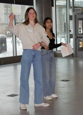 Two students link arms while participating in an activity. 