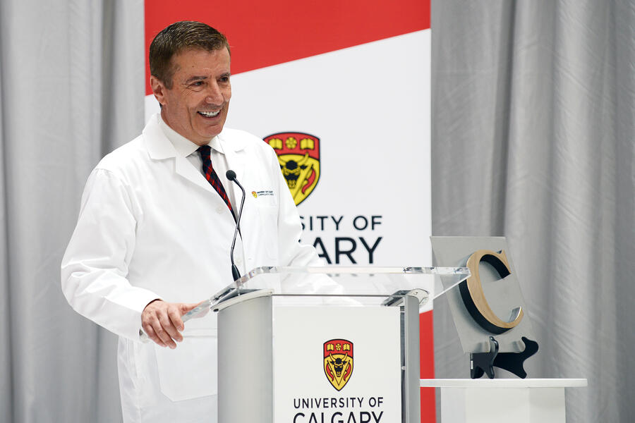 man in a lab coat standing at a podium