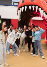 Students gather for a selfie under the giant inflatable Dinos head.