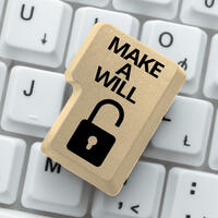 A enter key that is beige in colour with the words "make a will" written on top with a unocked lock