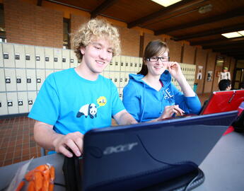Students smiling and looking at the computer