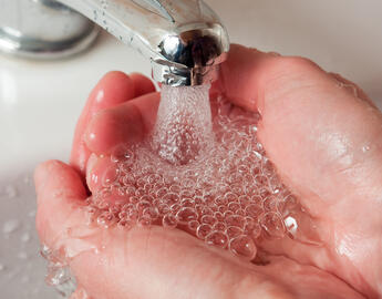 Washing hands under a tap. 
