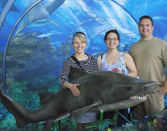 a young woman at the aquarium with her parents