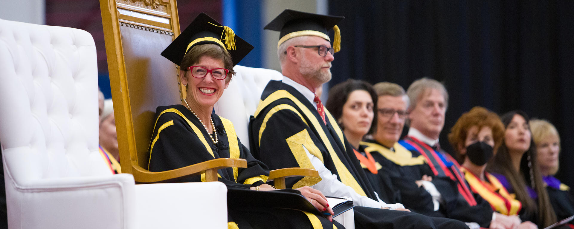 UCalgary Chancellor Deborah Yedlin sits in a chair on the stage while presiding over the Monday, May 30, convocation ceremony for the faculties of Medicine, Law, Nursing, and Vet Med. 