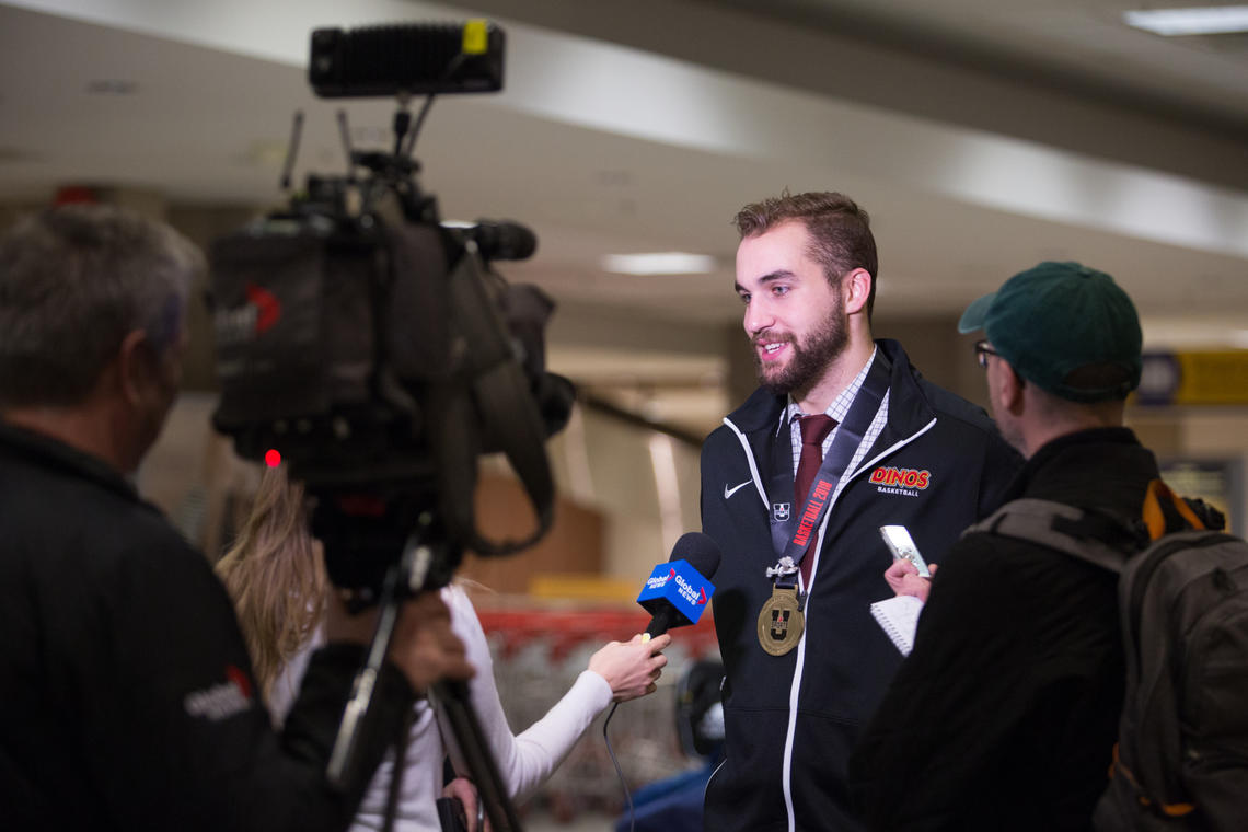 Graduating player Connor Foreman speaks to media at the Calgary airport as the Dinos return from U Sports championships with first-ever national basketball title. 