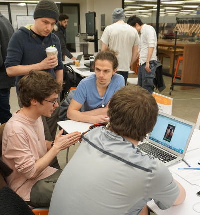 Computer science instructor Sasha Ivanov, sitting, left, discusses feedback with the nursing posture app team at the first iOS app prototype feedback session Feb. 14.