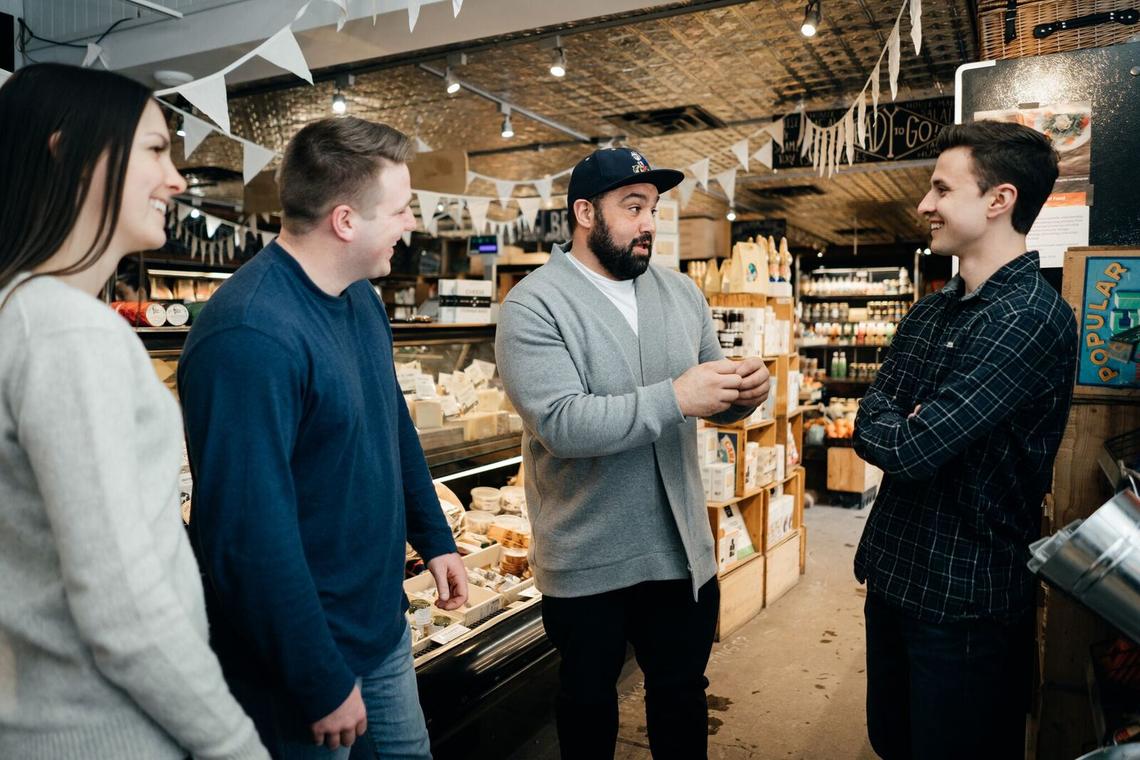 From left: Students Alyssa Froese and Brodie Pierson meet with Yousef Traya, the owner of Bridgeland Market, and fellow student Tanner Shapka, to discuss the challenges and opportunities in Bridgeland.