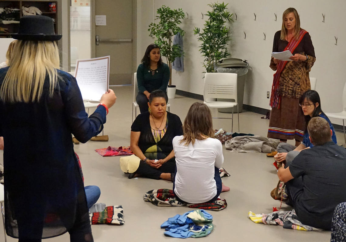 Darlene Cox leads the KAIROS Blanket Exercise during which facilitators read from scrolls detailing Indigenous history.