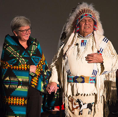 Provost and Vice-President (Academic) Dru Marshall is gifted a Blackfoot name (Chickadee Song) by Dr. Reg Crowshoe at the Indigenous Strategy launch on Nov. 16. 