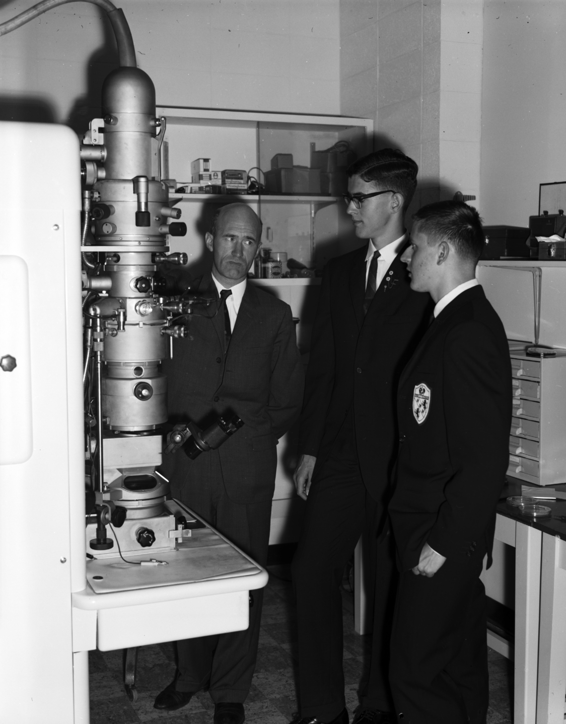 From left, Dr. Cyril E. Challice of the physics department with Canadian Association of Physicists prize winners James Prescott and Stephen Hernadi standing next to the university's electron microscope, 1960. 