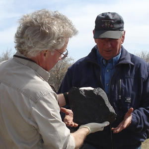 Alan Hildebrand (left) and Al Mitchell examine the meteorite fragment. Mitchell dontated the large fragment to the U of C