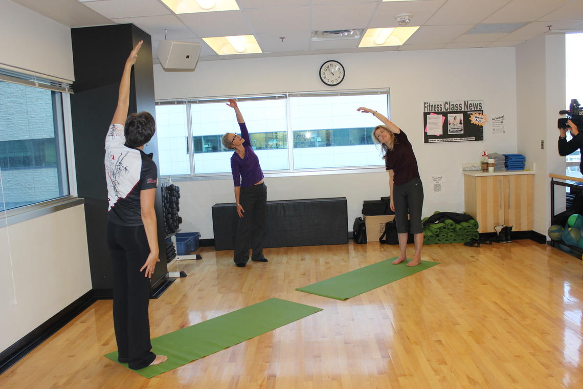 Linda Carlson, centre, and two breast cancer survivors demonstrate some of the yoga poses they did as part of the study.