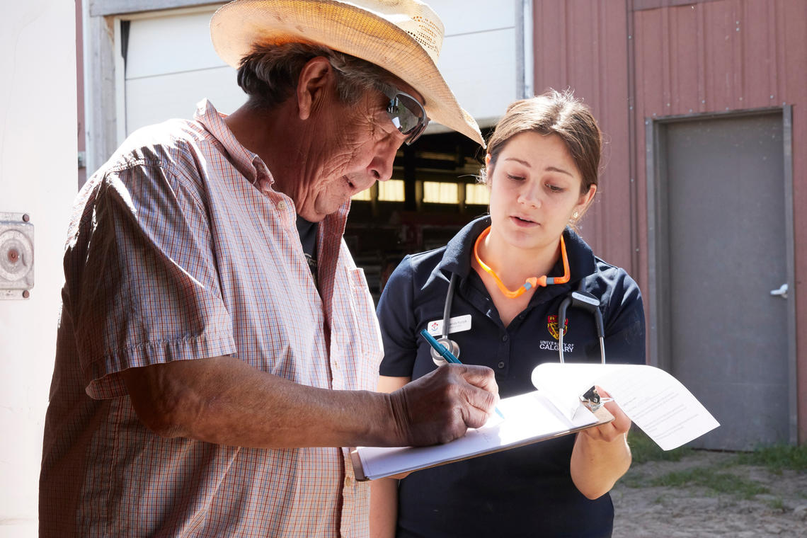 Marvin Dodginghorse checks medical records on Ollie with UCVM student Amanda Kuzyk. 