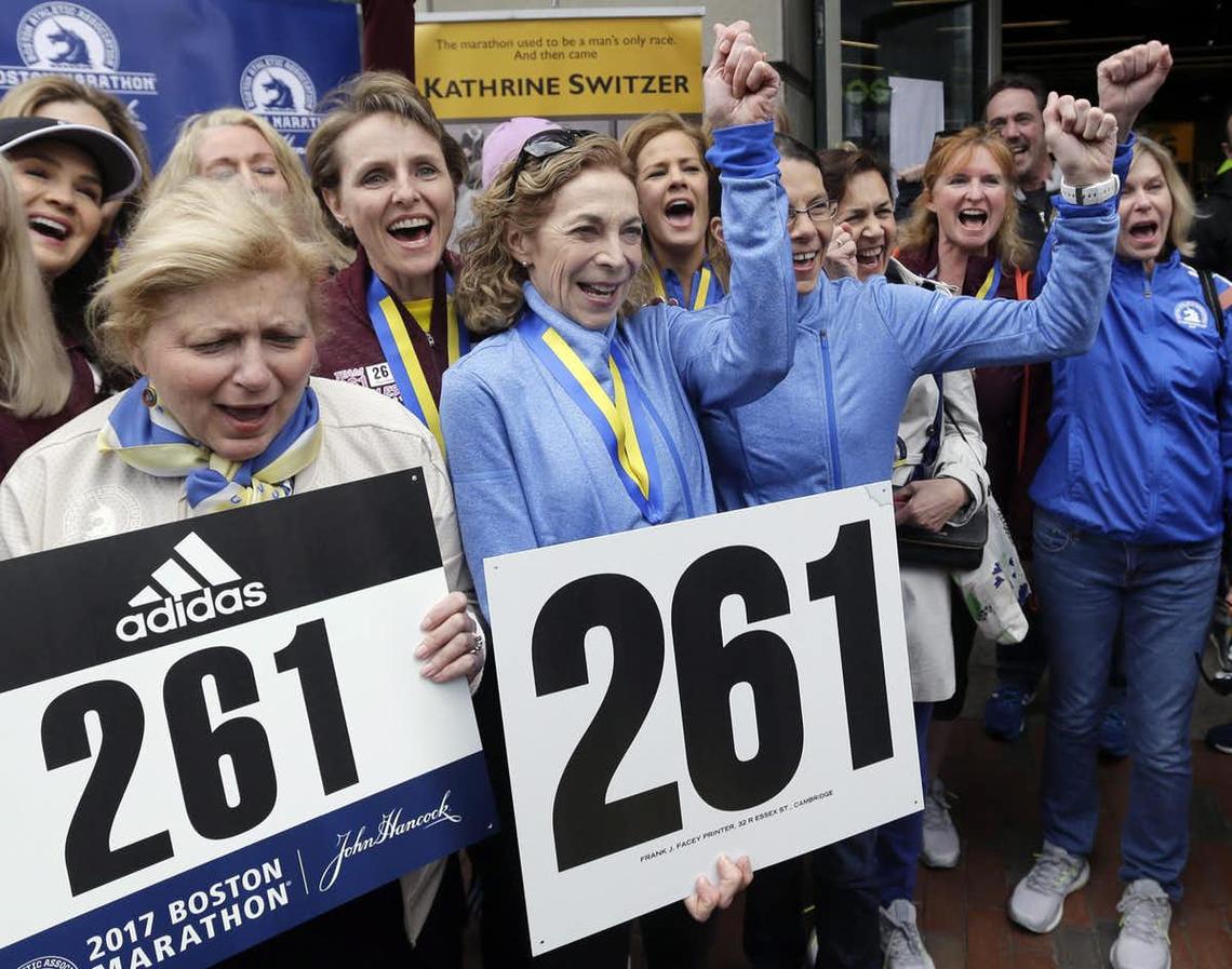 Kathrine Switzer, middle with fist up, the first official woman entrant in the Boston Marathon 50 years ago, cheers at a news conference, Tuesday, April 18, 2017, in Boston, where her bib No. 261 was retired in her honour by the Boston Athletic Association.