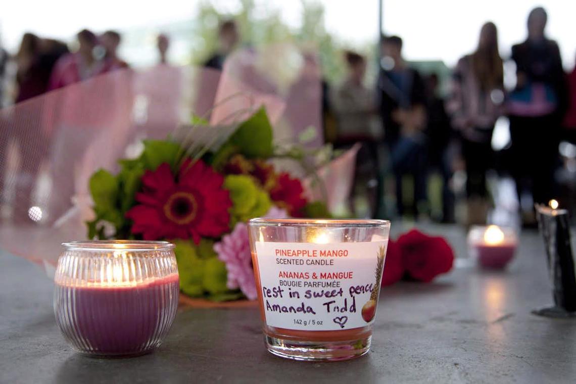 Flowers and candles are seen as people gather at a memorial honouring teen Amanda Todd in Maple Ridge, B.C. in October 2012.