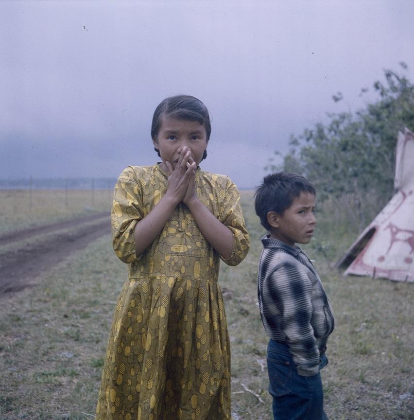 Two Indigenous children with teepee in background