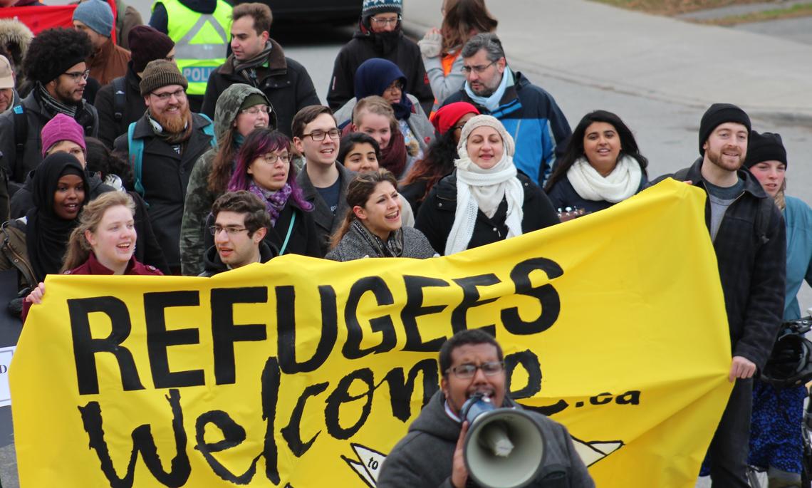 Protesters with sign saying 'Refugees welcome'