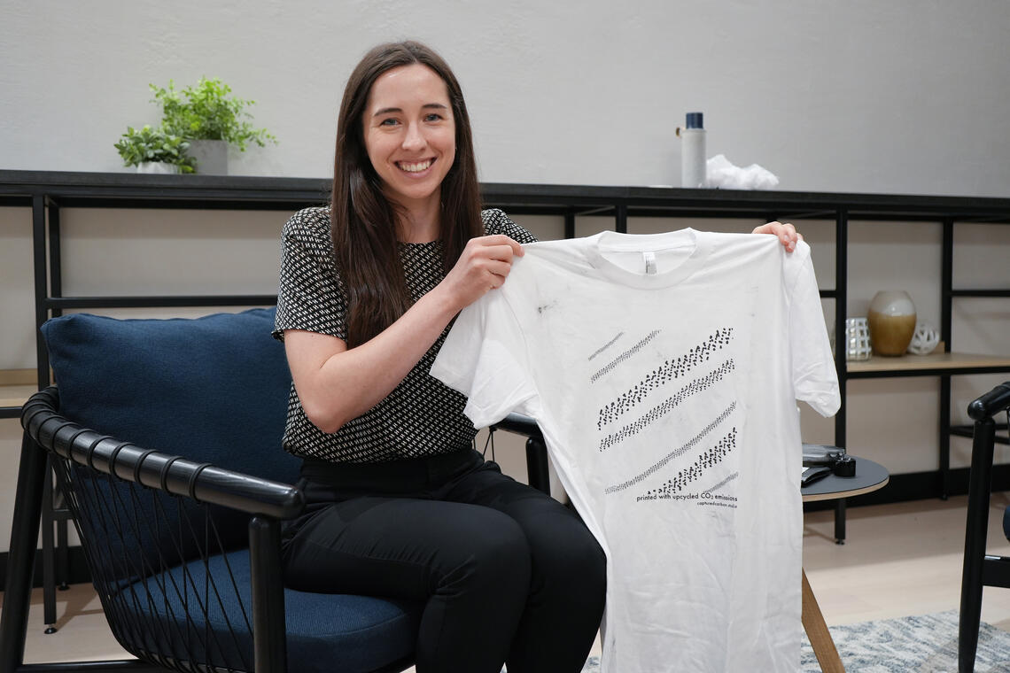 Madison Savilow holding Oco’s first screen-printed shirt designed by their artist-in-residence, Annalee Levin in 2019.