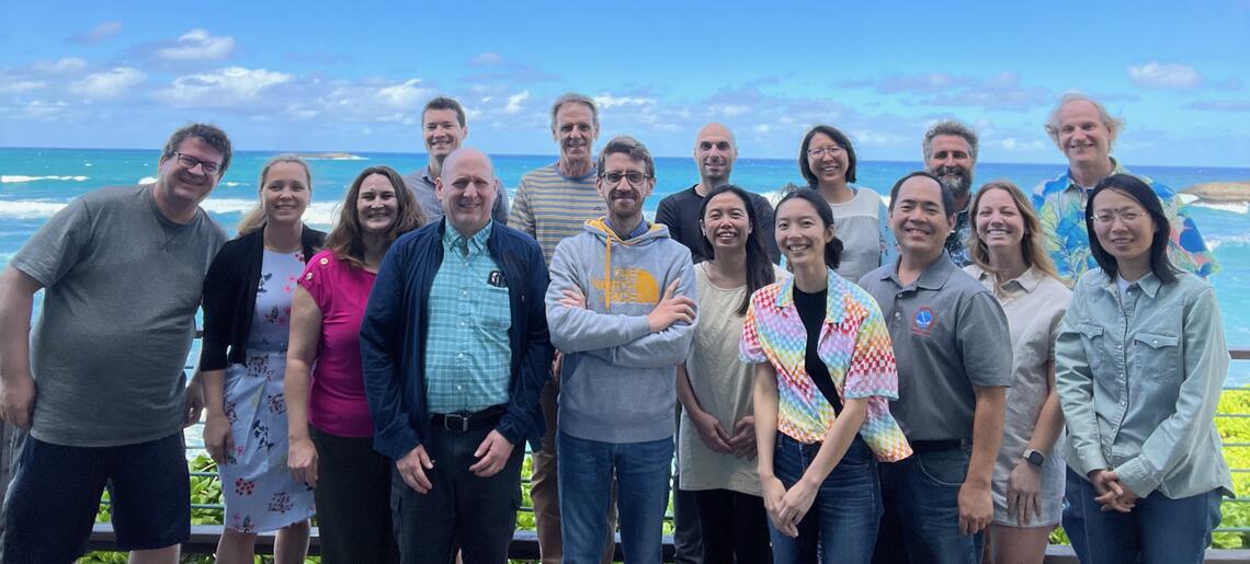 Group photo of the researchers involved in the summit in front of a beach
