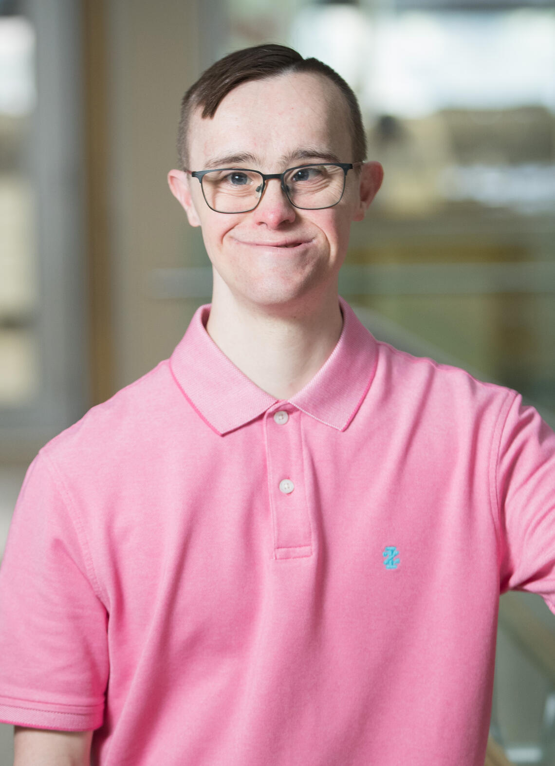 A man wearing a pink shirt and glasses