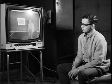 A University of Calgary teacher-in-training watches a video of himself present a lesson as part of an approach known as microteaching, used to help student teachers evaluate and perfect their technique. 1967. UARC82.011.4.26