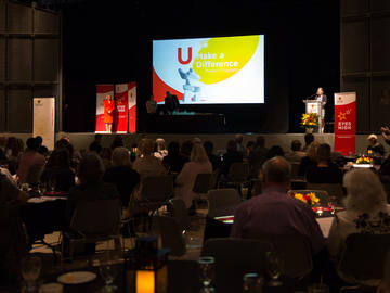 Linda Dalgetty announcing this year’s U Make a Difference Award recipients with assistance from Dr. Ed McCauley