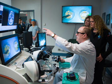 Dr. Sutherland demonstrates the work of the Symbis to Gov. Gen. Julie Payette. The Symbis is a robotic arm that is controlled in an adjacent room. Having no personnel in the room allows for more screening without interrupting surgery.