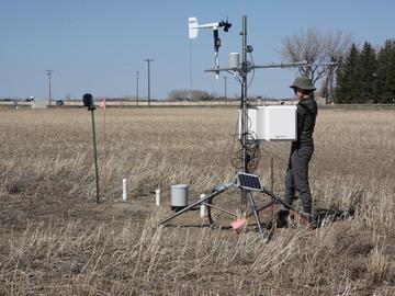 UCalgary hydrology grad student Alex Hughes checks a weather station at a drier spot in a farmer’s field outside of Lethbridge on April 23