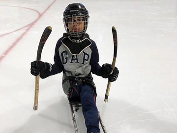 Adapted camp participant playing hockey