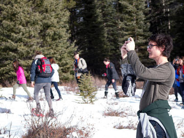 A student takes a photo of himself in the mountains