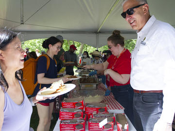 Vice-President (Research) William Ghali serves beef on a bun to community members during the President's Stampede BBQ on July 12. 