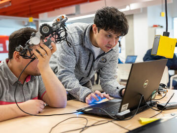 robotics workshop participants programming a robot from a computer