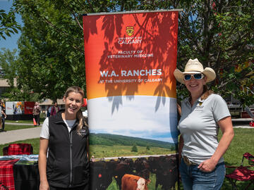 Heather Mitchell-Matheson (Program Development co-ordinator) and Kirsten Glowa Kobe (manager, Marketing and Communications) with a pull-up banner promoting W.A. Ranches at the barbecue.