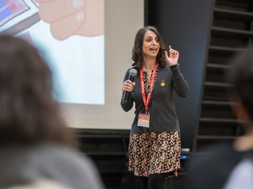 Sarah stands on stage pitching