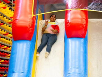 A person slides down a bouncy castle slide